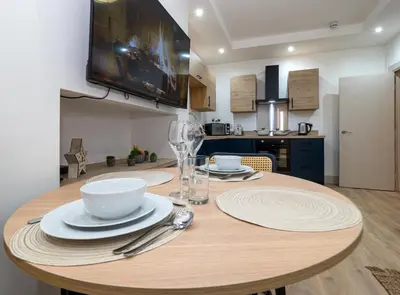 a wooden table with plates and bowls on it in a kitchen at Bohemian Apartment, free WiFi and parking in New Brighton