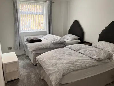 a room with three beds and a window at 2 Bedroom Beachside House Sleeps 4 - Private Patio in Southport