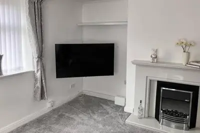a living room with a television and a fireplace at 2 Bedroom Beachside House Sleeps 4 - Private Patio in Southport