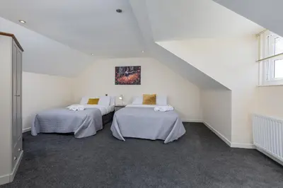 two beds in a room with white walls at Spacious Luxurious Serviced Accommodation 6 in Barrow in Furness