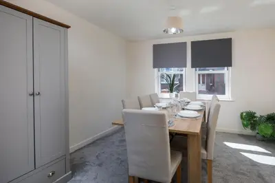 a dining room with a wooden table and chairs at Spacious Luxurious Serviced Accommodation 6 in Barrow in Furness