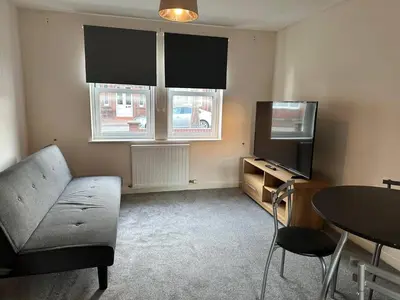 a living room with a couch and a tv and a table at House - Sleeps 12 - Parking - WiFi in Barrow in Furness