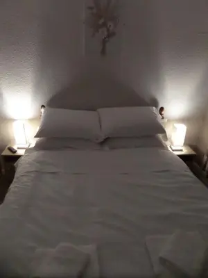 a large white bed with two lamps on both sides at Nathans in Blackpool