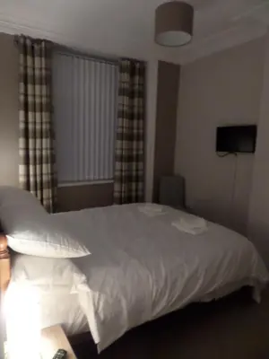 a bedroom with a white bed and a window at Nathans in Blackpool