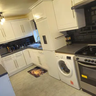 a kitchen with white cabinets and a washing machine at West park Royal House, Holidays, Contractors,Relocation,Free Parking & WiFi in Preston