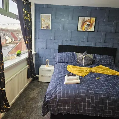 a bedroom with a bed with a blue wall at West park Royal House, Holidays, Contractors,Relocation,Free Parking & WiFi in Preston