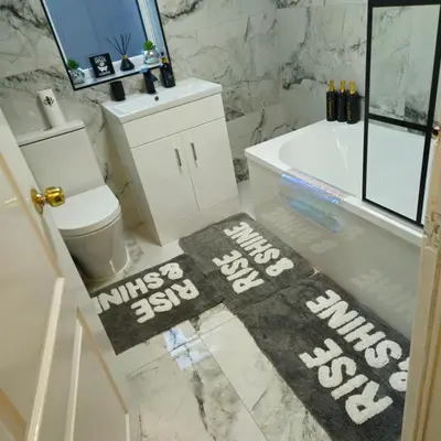 a bathroom with a tub and a toilet and a rug at West park Royal House, Holidays, Contractors,Relocation,Free Parking & WiFi in Preston