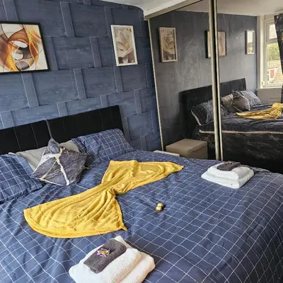 a bedroom with a blue bed with towels on it at West park Royal House, Holidays, Contractors,Relocation,Free Parking & WiFi in Preston