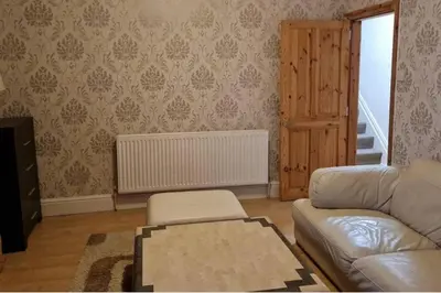 a living room with a couch and a table at 4 Bed House Sleeps 8 - Pet Friendly with Garden in Blackpool