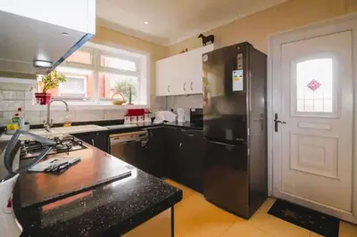 a kitchen with a stainless steel refrigerator and a counter at 4 Bed House Sleeps 8 - Pet Friendly with Garden in Blackpool