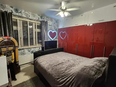 a bedroom with a red wall with a heart painted on it at house with hot tub in West Derby