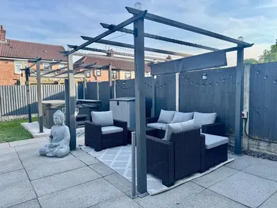 a gazebo with a statue sitting on a patio at house with hot tub in West Derby