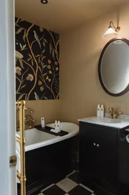 a bathroom with a tub and a sink and a mirror at Cartmel Old Grammar in Cartmel