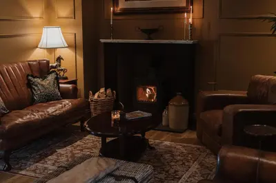a living room with a couch and a fireplace at Cartmel Old Grammar in Cartmel