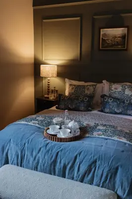 a bed with a tray with cups and dishes on it at Cartmel Old Grammar in Cartmel