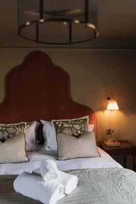 a bedroom with a large bed with white sheets and pillows at Cartmel Old Grammar in Cartmel