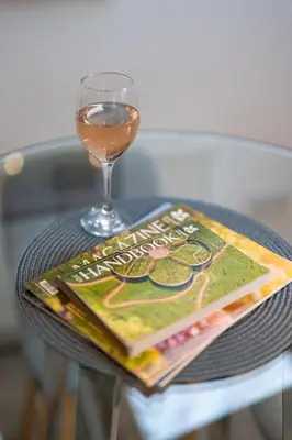 a book and a glass of wine on a table at Spacious & relaxing cottage stay with free parking in Cark