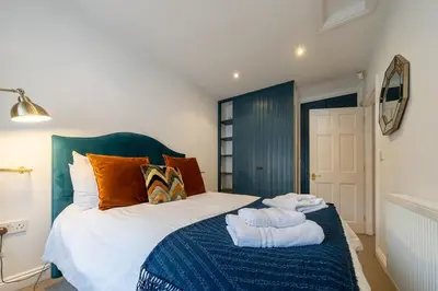a bedroom with a bed with towels on it at Spacious & relaxing cottage stay with free parking in Cark