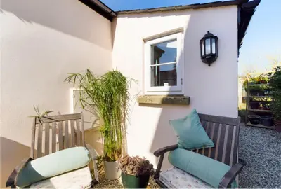 a patio with two chairs and a window at Spacious & relaxing cottage stay with free parking in Cark