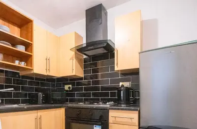a kitchen with a stove and a refrigerator at Kirkdale Apartment in Liverpool