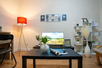 a living room with a table and a tv at Kirkdale Apartment in Liverpool