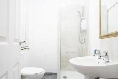 a white bathroom with a sink and a toilet at Kirkdale Apartment in Liverpool