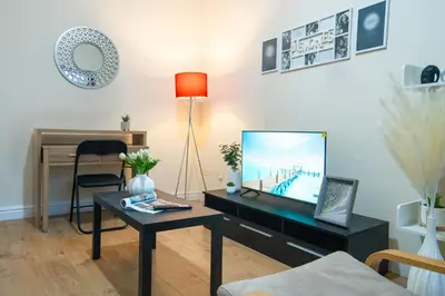 a living room with a flat screen tv on a table at Kirkdale Apartment in Liverpool