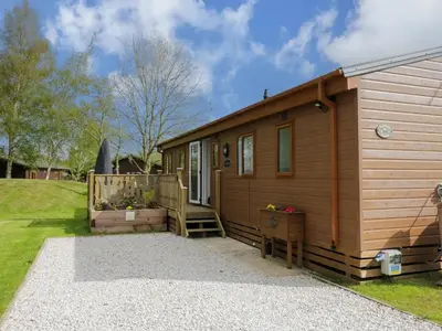 a wooden cabin with a porch and a door at Lakeland Lodge- 3Bed-2 Bath- Private Patio in Carnforth