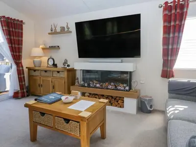 a living room with a fireplace and a flat screen tv at Lakeland Lodge- 3Bed-2 Bath- Private Patio in Carnforth