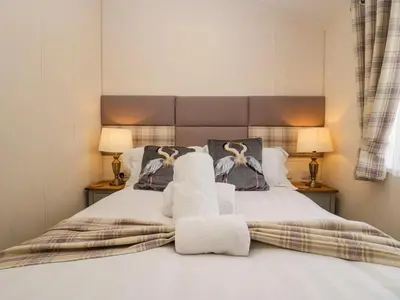 a bedroom with a bed with towels on it at Lakeland Lodge- 3Bed-2 Bath- Private Patio in Carnforth