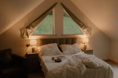 a bedroom with a bed with a large window at Landal Twin Lakes in Carnforth