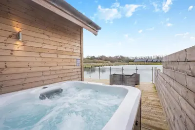 a bath tub sitting next to a wooden wall at Landal Twin Lakes in Carnforth