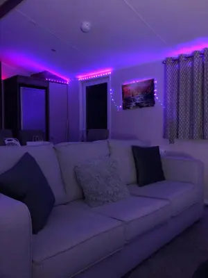a living room with a white couch with purple lights at Getaway in Longridge