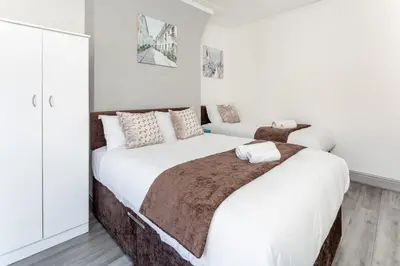 two beds in a bedroom with white walls at Fairburn House - Air Host & Stay - Contractor Friendly in Liverpool