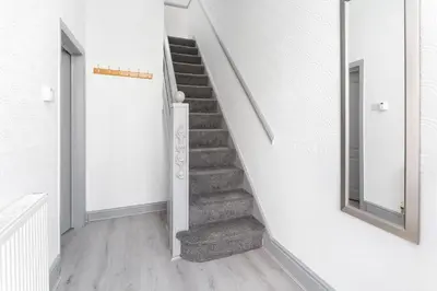 a staircase in a white room with a mirror at Fairburn House - Air Host & Stay - Contractor Friendly in Liverpool