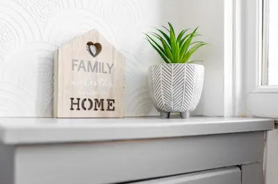 a shelf with a family sign and a plant at Fairburn House - Air Host & Stay - Contractor Friendly in Liverpool