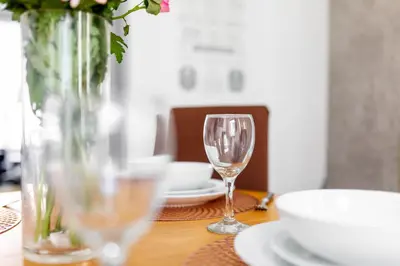 a wooden table with a vase and a wine glass at Fairburn House - Air Host & Stay - Contractor Friendly in Liverpool