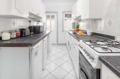 a white kitchen with white cabinets and a stove at Fairburn House - Air Host & Stay - Contractor Friendly in Liverpool