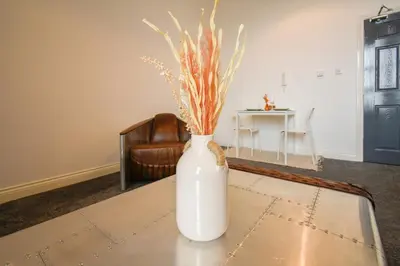 a white vase sitting on top of a table at Modern Suite Blackburn in Blackburn
