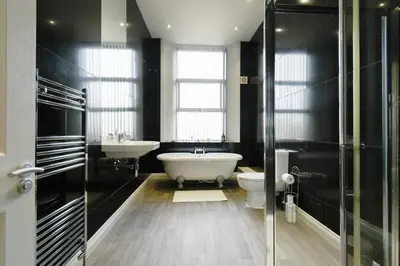 a bathroom with a tub and a toilet and a sink at Modern Suite Blackburn in Blackburn