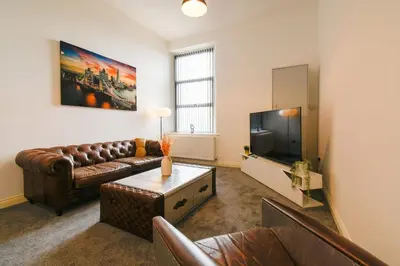 a living room with a couch and a tv at Modern Suite Blackburn in Blackburn