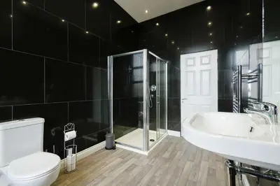 a bathroom with a toilet and a sink and a shower at Modern Suite Blackburn in Blackburn
