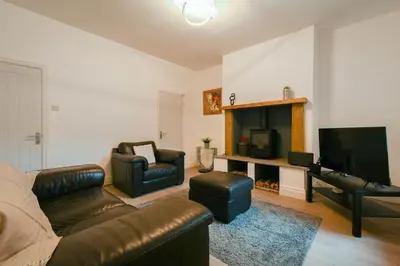 a living room with a couch and a television at Modern House Blackburn in Blackburn