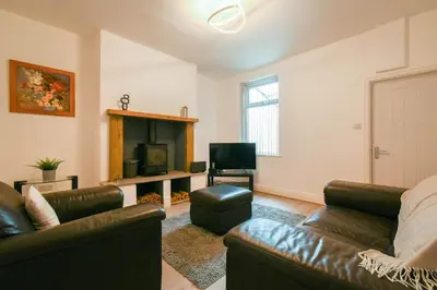 a living room with a couch and a television at Modern House Blackburn in Blackburn