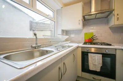 a kitchen with a sink and a stove and a window at Modern House Blackburn in Blackburn