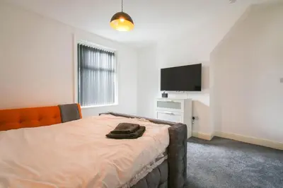 a bedroom with a bed and a flat screen tv at Modern House Blackburn in Blackburn