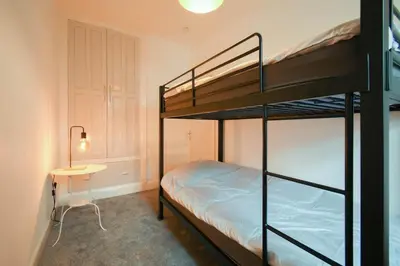 a bedroom with two bunk beds and a table at Modern House Blackburn in Blackburn