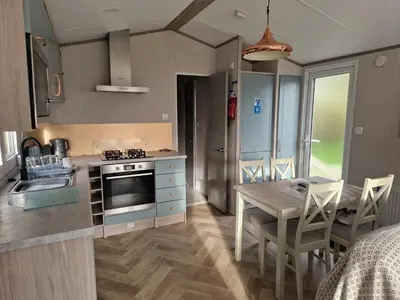 a kitchen with a table and a dining room at Lakeland Leaisure park Haven Caravan in Flookburgh