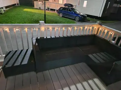 a bench on a deck with a car in a yard at Lakeland Leaisure park Haven Caravan in Flookburgh