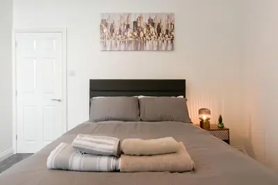 a bedroom with a bed with two towels on it at Suite in the center of Great Harwood in Great Harwood